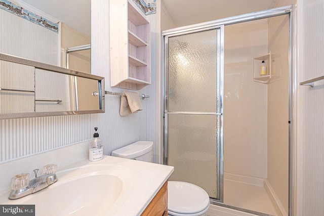 bathroom with a stall shower, vanity, and toilet