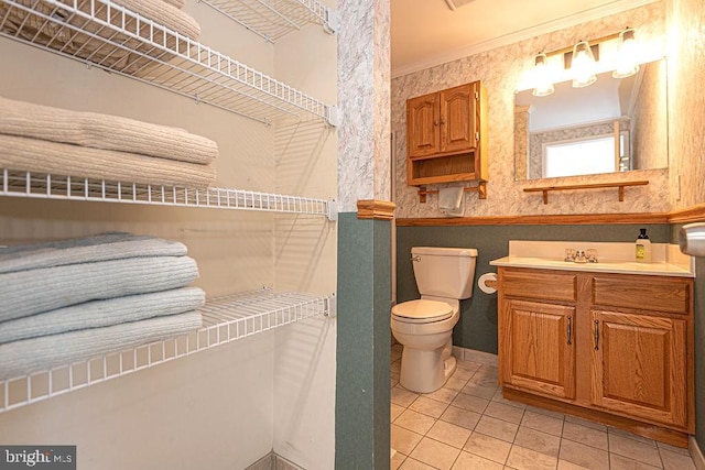 bathroom featuring toilet, tile patterned flooring, crown molding, and vanity