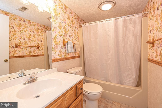 bathroom featuring wallpapered walls, visible vents, a textured ceiling, and wainscoting