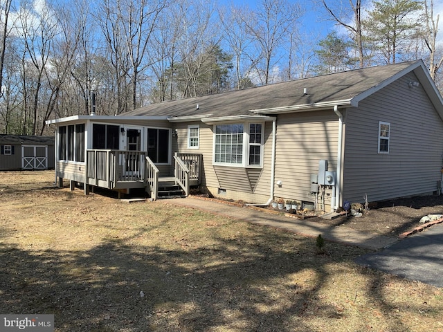 view of front of house with an outbuilding, a storage unit, crawl space, and a sunroom