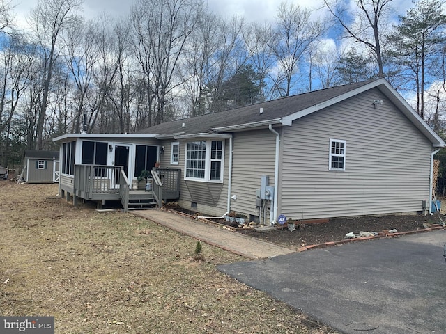 exterior space featuring an outbuilding, a deck, and a storage unit