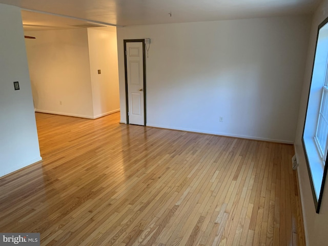 unfurnished room with baseboards and light wood-style floors