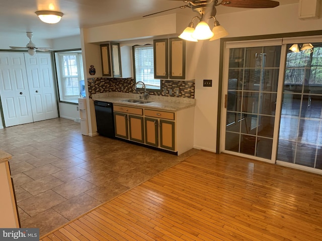 kitchen with black dishwasher, tasteful backsplash, plenty of natural light, and a sink