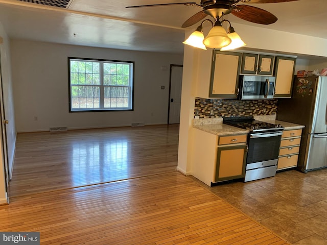 kitchen with visible vents, decorative backsplash, light wood-style flooring, stainless steel appliances, and light countertops