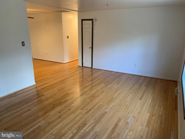 spare room with light wood finished floors, baseboards, and a ceiling fan