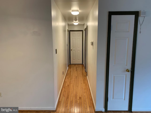 hallway featuring light wood-style floors and baseboards