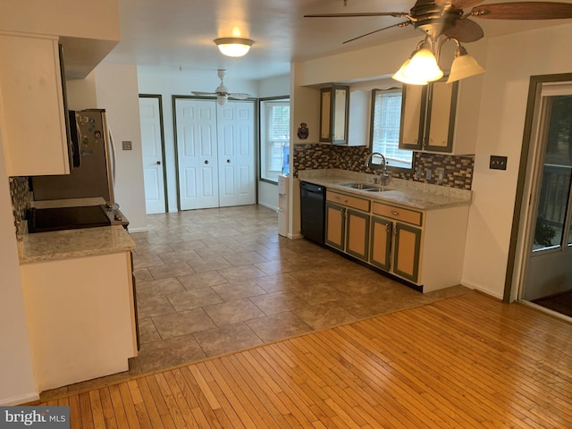 kitchen with stainless steel appliances, light countertops, decorative backsplash, a sink, and ceiling fan