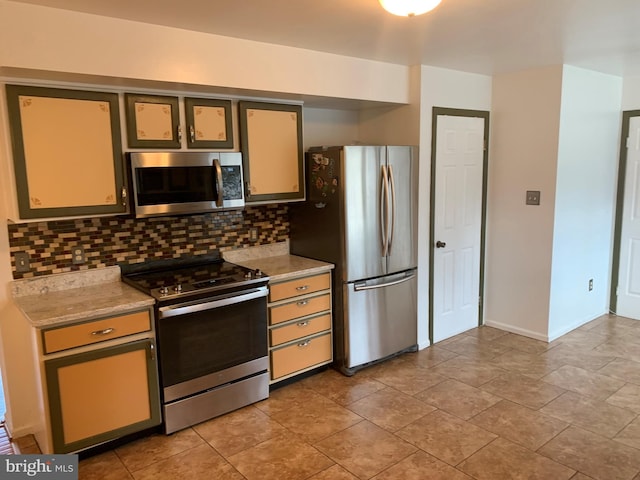 kitchen with light tile patterned floors, stainless steel appliances, backsplash, and baseboards