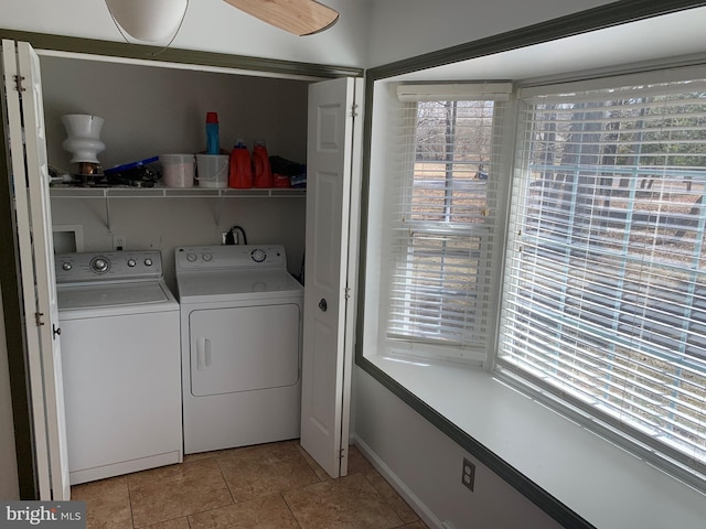 clothes washing area featuring laundry area, plenty of natural light, washing machine and dryer, and light tile patterned flooring