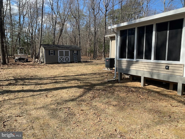 view of yard featuring a shed, central AC, and an outbuilding