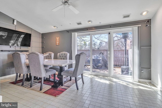 dining area with visible vents, baseboards, a ceiling fan, and vaulted ceiling