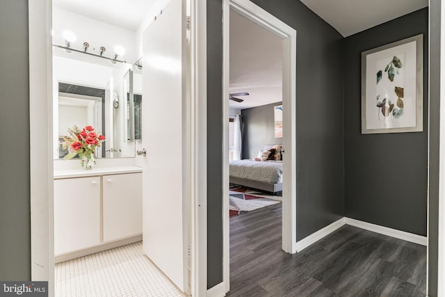 hall with baseboards and wood finished floors