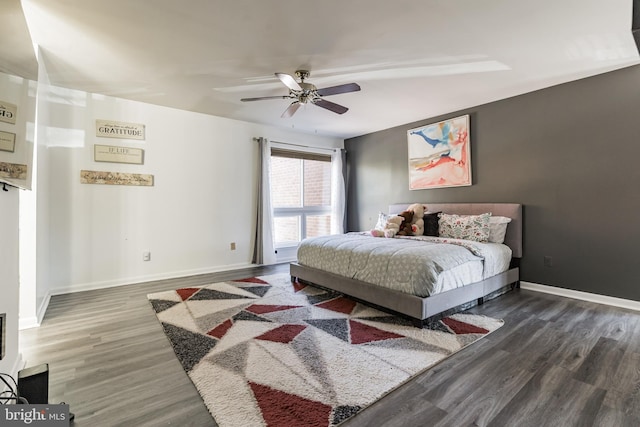 bedroom featuring ceiling fan, baseboards, and wood finished floors