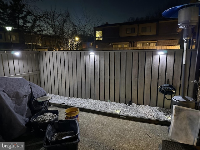 patio at night with a fenced backyard