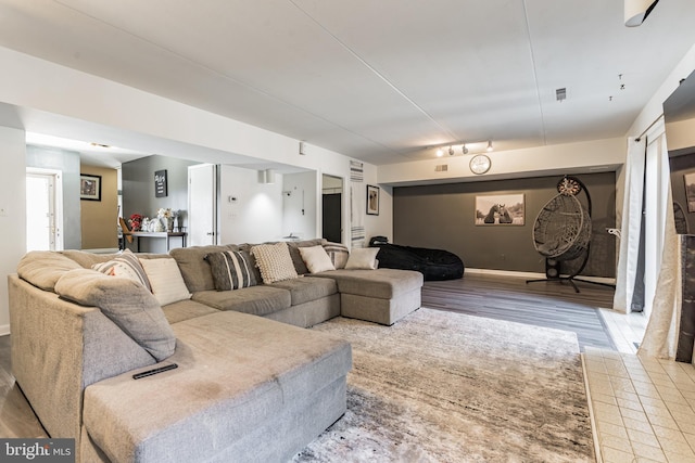 living room with visible vents, rail lighting, baseboards, and wood finished floors