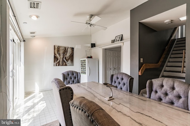 dining space featuring tile patterned floors, stairway, a ceiling fan, and visible vents