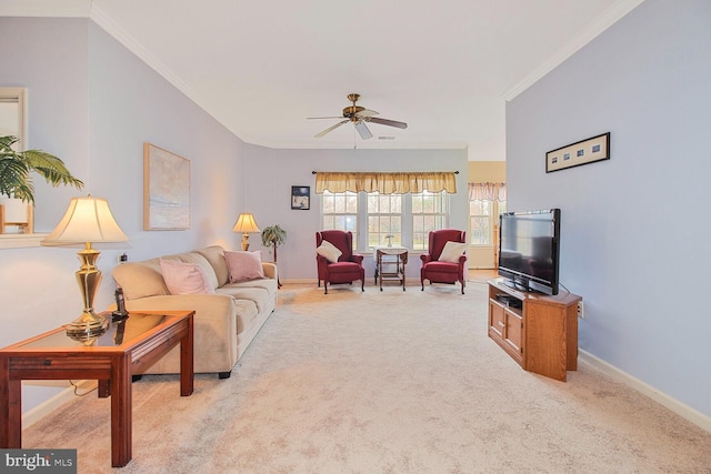 living area featuring light carpet, a ceiling fan, baseboards, and ornamental molding