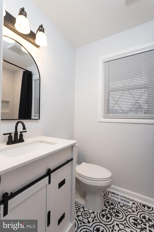 bathroom featuring toilet, tile patterned flooring, baseboards, and vanity