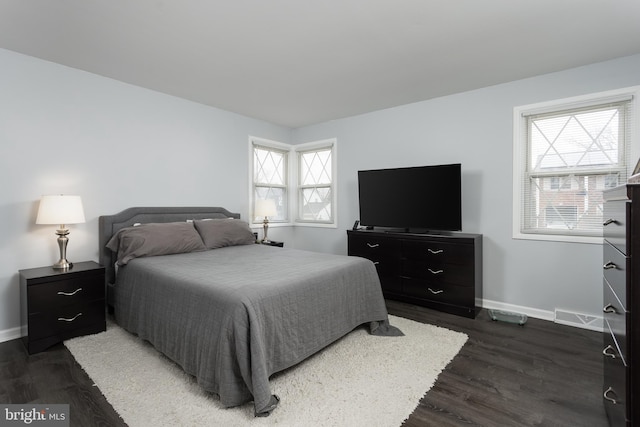 bedroom with visible vents, baseboards, and dark wood-type flooring