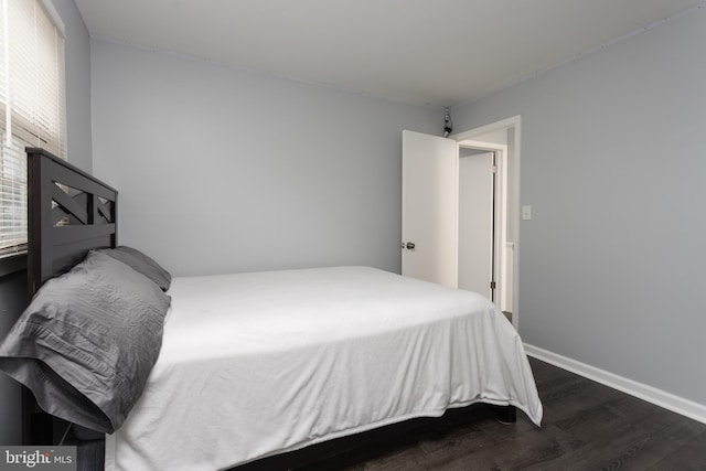 bedroom featuring dark wood-type flooring and baseboards