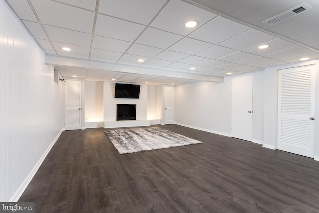 below grade area with recessed lighting, dark wood-style flooring, a fireplace, visible vents, and baseboards