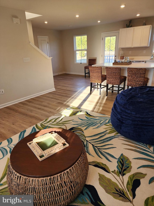 living area with light wood-type flooring, baseboards, and recessed lighting