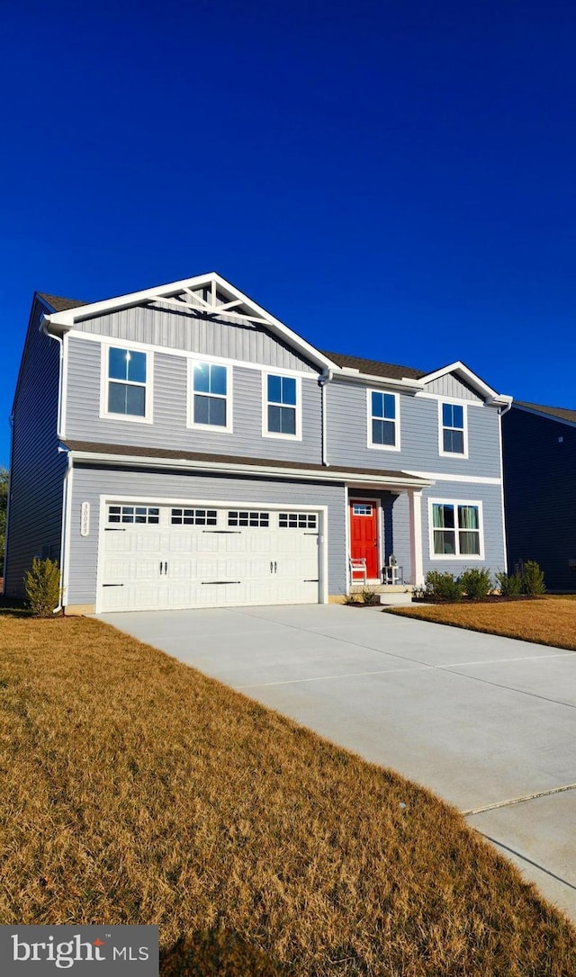 view of front of house with a garage, driveway, a front lawn, and board and batten siding