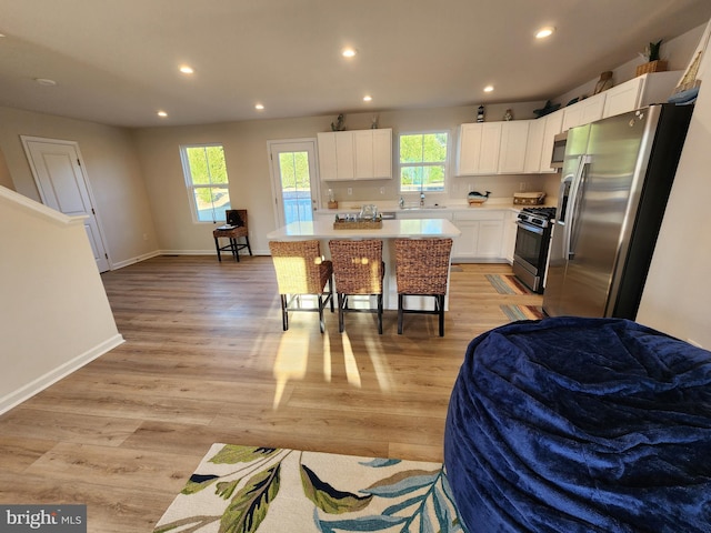 kitchen featuring stainless steel appliances, recessed lighting, a healthy amount of sunlight, and white cabinets