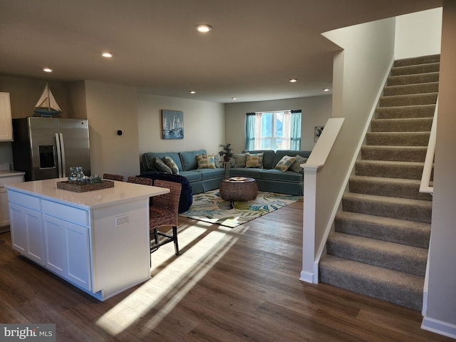 living area with stairs, dark wood-type flooring, baseboards, and recessed lighting