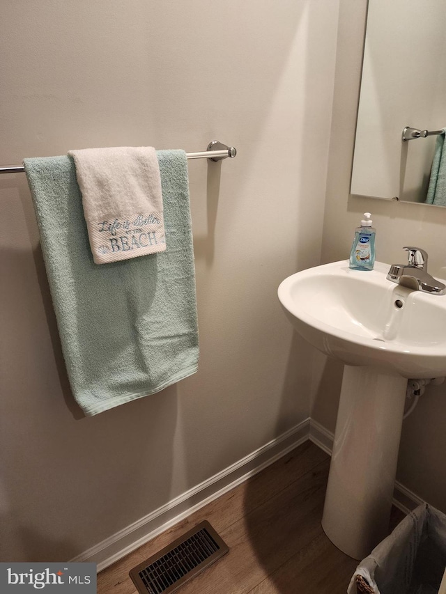 bathroom with visible vents, baseboards, and wood finished floors