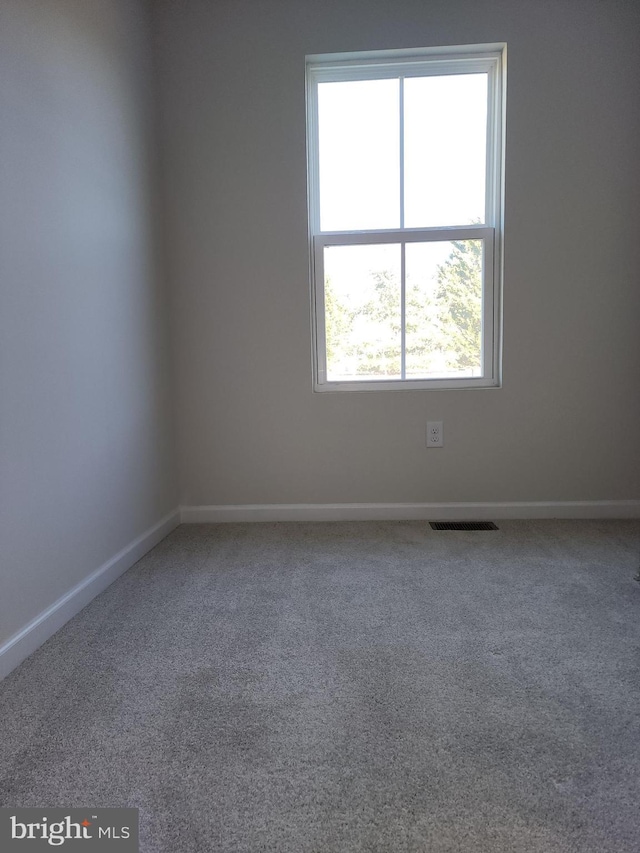 carpeted empty room with visible vents and baseboards