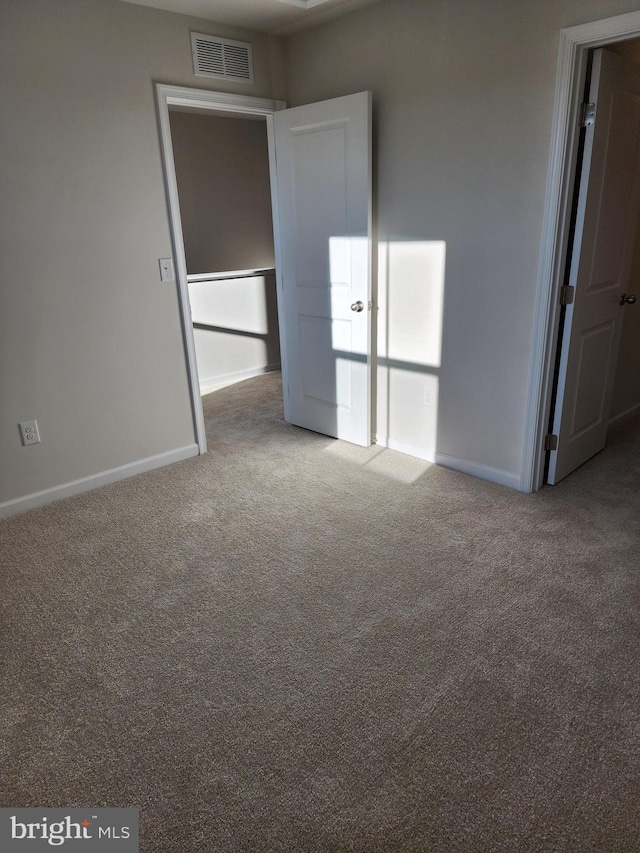 unfurnished bedroom featuring carpet flooring, visible vents, and baseboards