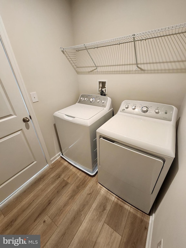 laundry room featuring light wood-type flooring, laundry area, and separate washer and dryer