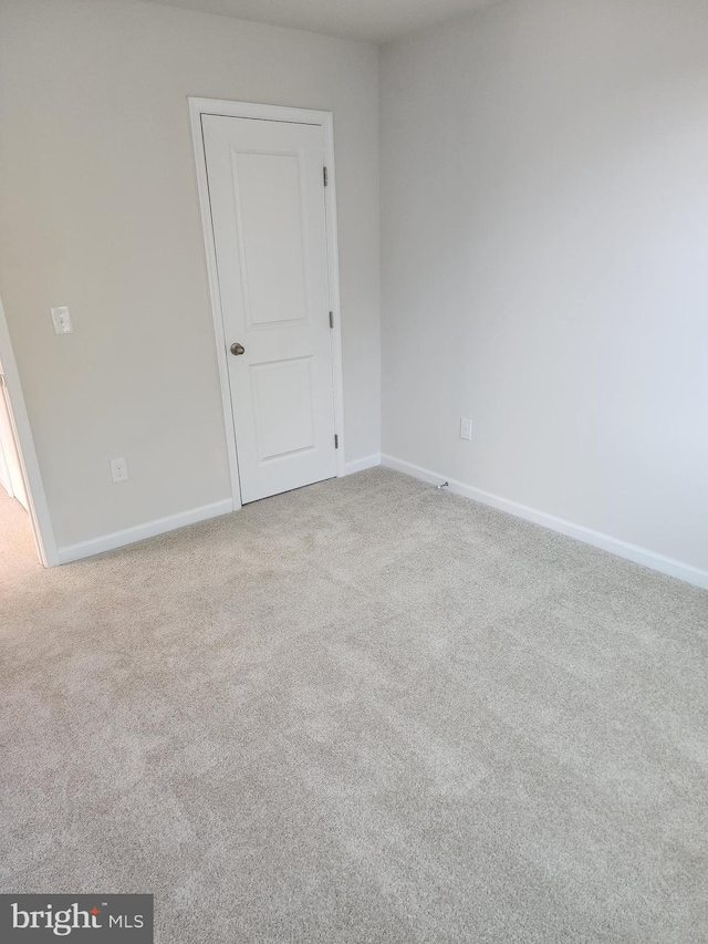 carpeted empty room with baseboards