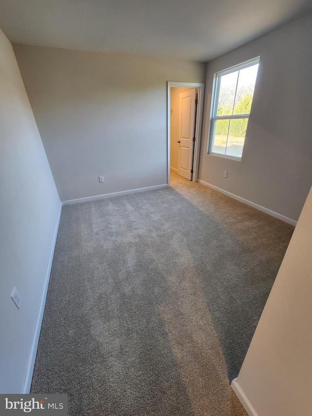 unfurnished bedroom featuring carpet floors and baseboards