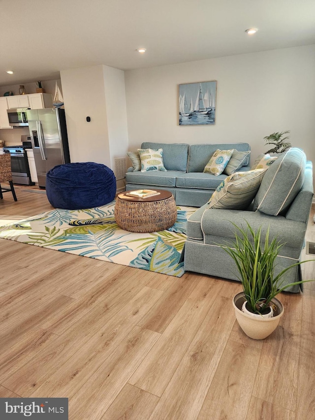 living area with light wood-type flooring and recessed lighting