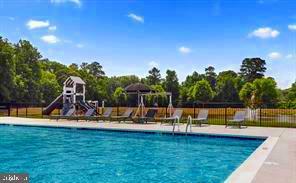 community pool with playground community and fence