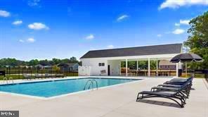 community pool with fence and a patio