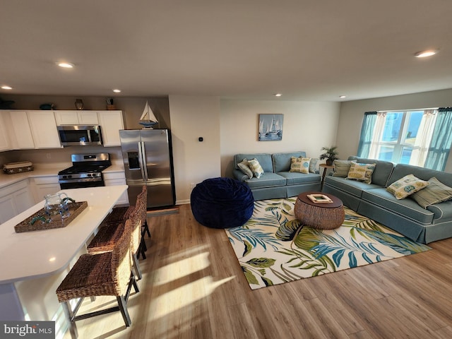 living area with recessed lighting and wood finished floors