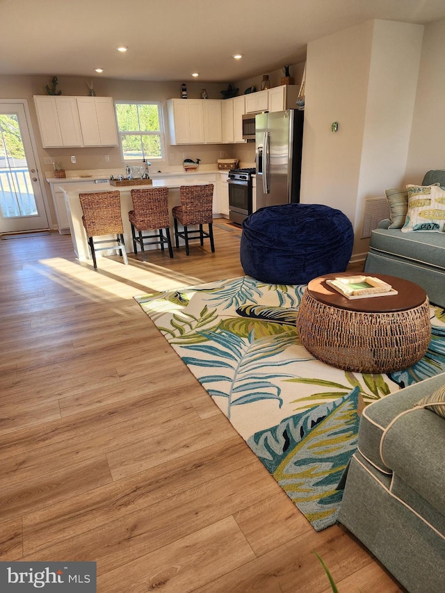 living area with light wood-style floors and recessed lighting