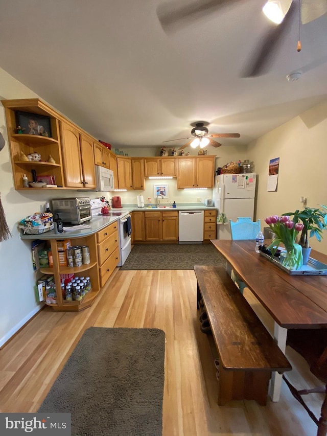 kitchen featuring white appliances, light wood-type flooring, open shelves, and a sink