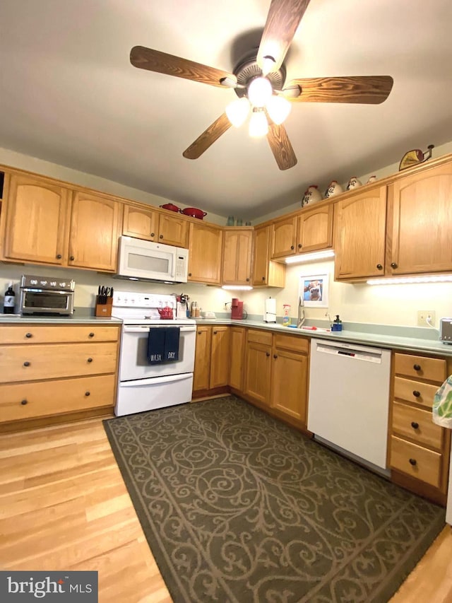 kitchen with white appliances, a ceiling fan, a toaster, a sink, and dark wood-type flooring