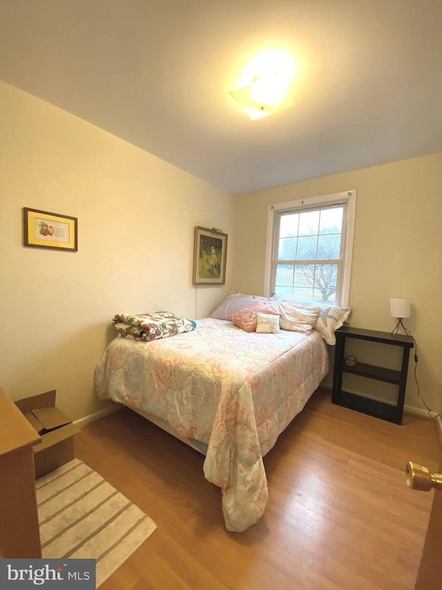 bedroom featuring baseboards and wood finished floors