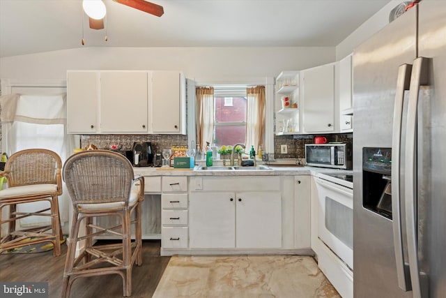 kitchen featuring a ceiling fan, decorative backsplash, light countertops, appliances with stainless steel finishes, and white cabinetry