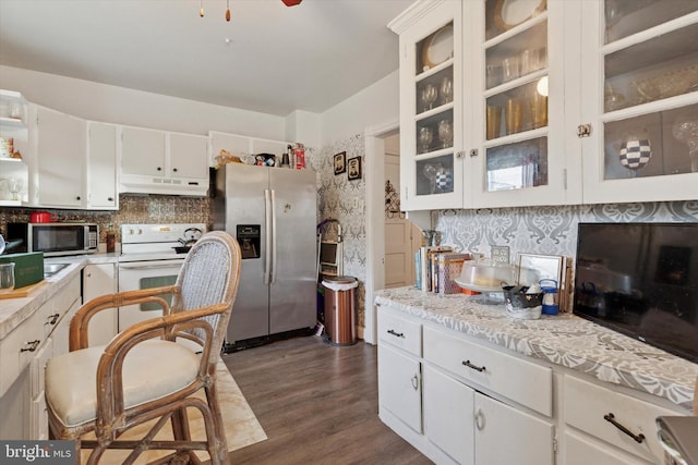 kitchen with stainless steel appliances, light countertops, dark wood-type flooring, under cabinet range hood, and white cabinetry