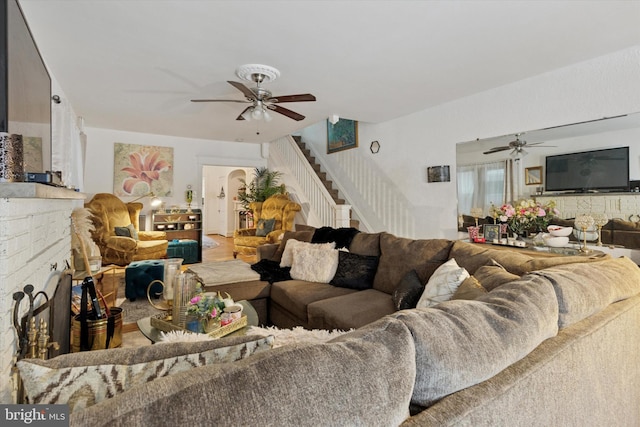 living room with ceiling fan and stairs