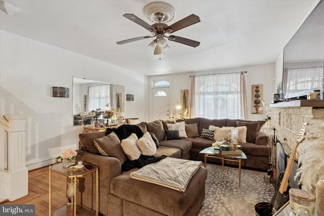 living room with a fireplace and ceiling fan