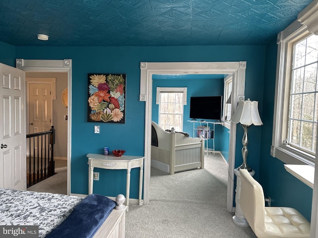 bedroom with carpet flooring, an ornate ceiling, and baseboards