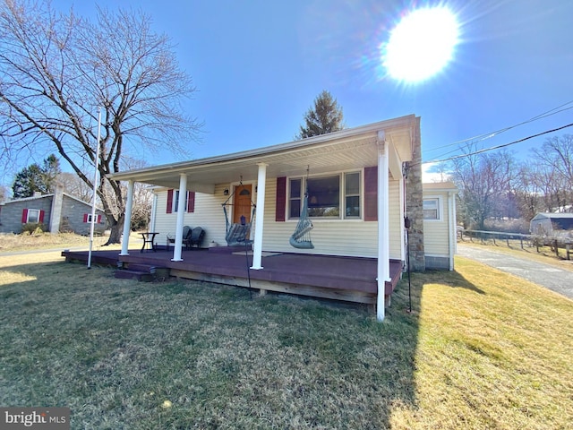 view of front of house with covered porch and a front lawn