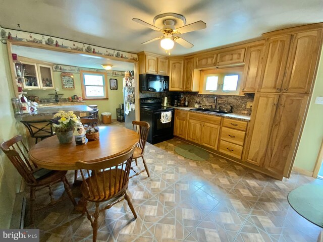 kitchen featuring tasteful backsplash, light countertops, a sink, ceiling fan, and black appliances